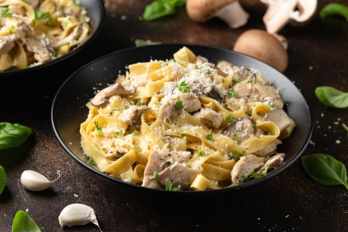 Creamy Alfredo pasta with chicken, mushrooms and parmesan cheese. Healthy Italian food.