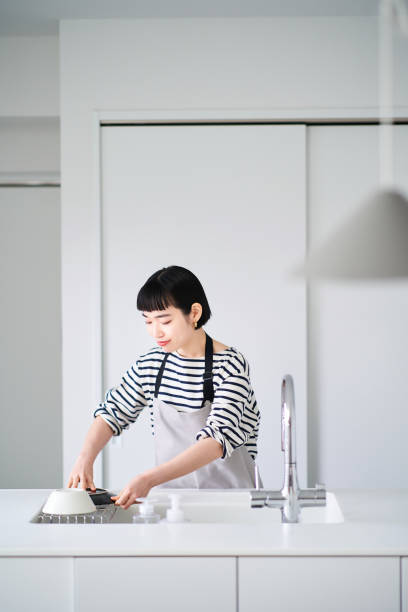 istock Woman washing dishes in the kitchen 1451115215