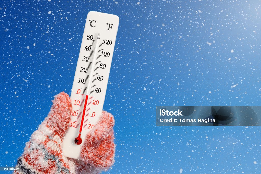 White celsius and fahrenheit scale thermometer in hand. Ambient temperature zero degrees celsius Arctic Stock Photo