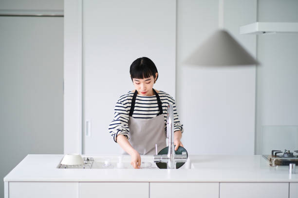 istock Woman washing dishes in the kitchen 1451115897
