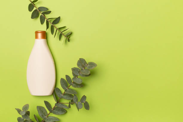 istock Cosmetic bottle with eucalyptus branch on color background, top view 1451116586