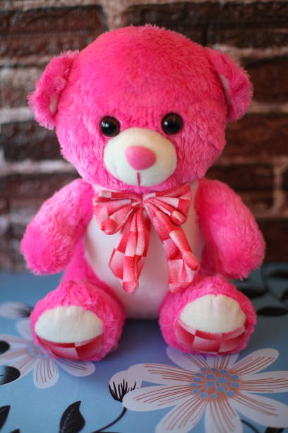istock Pink teddy bear with white details and a bow 1451117683