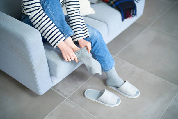istock Young woman putting on socks 1451117875