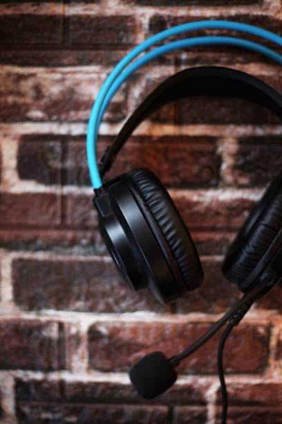 istock black headphones with blue details on a brick background 1451118136