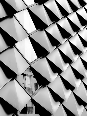 A close up black and white shot of details of modern building with geometric shaped construction