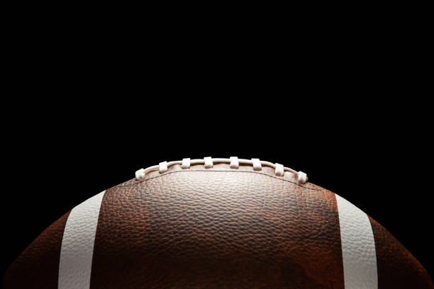 American football ball on dark background. American football ball on dark background with space for text. lace up stock pictures, royalty-free photos & images