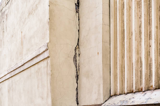Huge crack on the corner of building with metallic plaster mesh. Grid. House. Problem. Issue. Demolishing. Damage. Dangerous. Fracture
