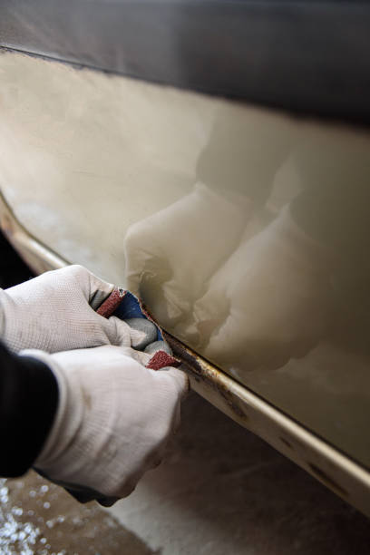 istock Car rust. Cleaning rust on the body with sandpaper 1451124962