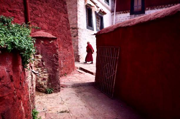 ガンデン僧院の赤い壁の間の赤い服を着た僧侶、チベット、中国 - tibet monk buddhism tibetan culture ストックフォトと画像