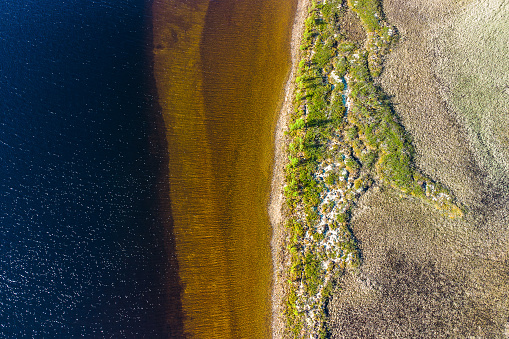 Aerial drone view of an idyllic lake in an norwegian national park with different shades and colors