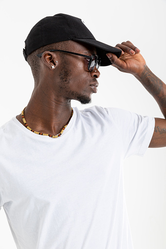 African-American man in white t-shirt wearing sunglasses against white background.