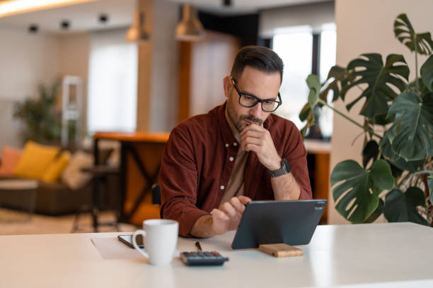 istock A businessman focused on his project working on a digital tablet from a home office 1451131706