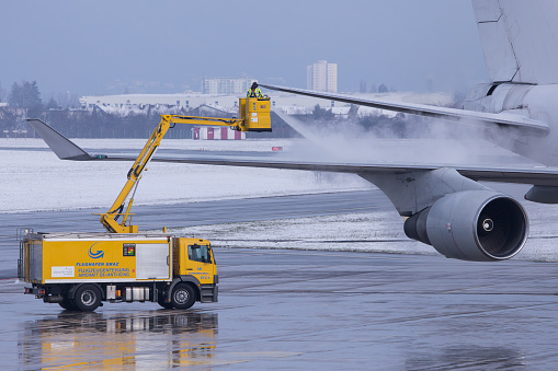 Graz, Austria - 20.03.2021: Anti-icing in progress at a Boeing 747 at airport Graz in Austria during cold weather conditions