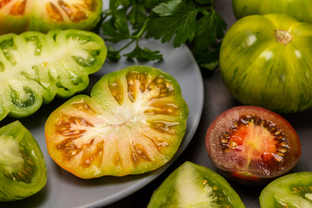 istock Green chopped tomatoes on a gray plate close-up. 1451135265
