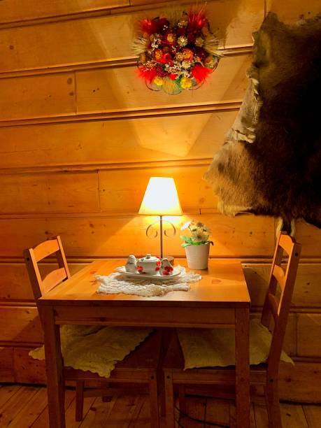 istock Idyllic wood table with teapot, illuminating lamp and two chairs 1451137658