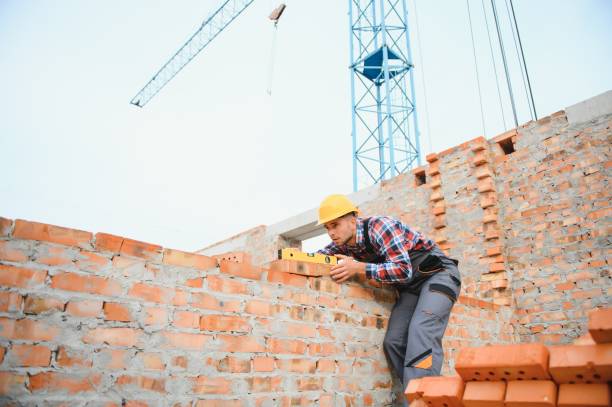 istock Yellow colored hard hat. Young man working in uniform at construction at daytime. 1451138020