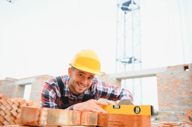 istock Yellow colored hard hat. Young man working in uniform at construction at daytime. 1451138364