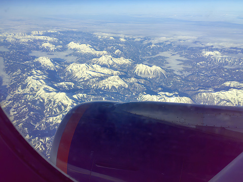 View on snow mountain chain peaks from a plane by clear weather