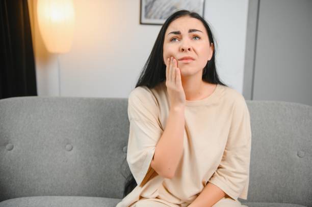 istock Young woman suffering from toothache at home 1451144323