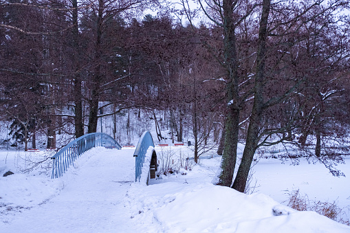 Winter landscape, pedestrian bridge in the city park. Everything is snowy. Lahti City Park Finland