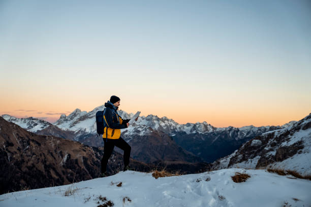 Man in a rural winter location checking his map