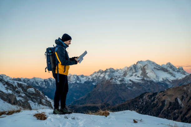 istock Young man with map standing on top of the hill 1451148859