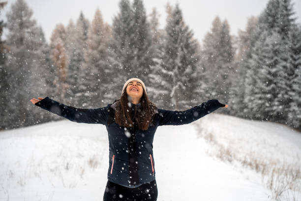 istock Happy woman enjoying falling snow in field 1451148911