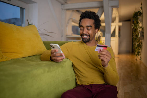 istock Cheerful man doing online shopping 1451150322