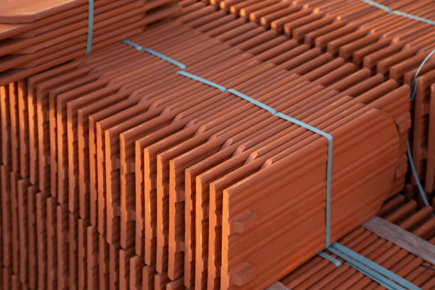 Stack of new ceramic roof tiles on construction site.