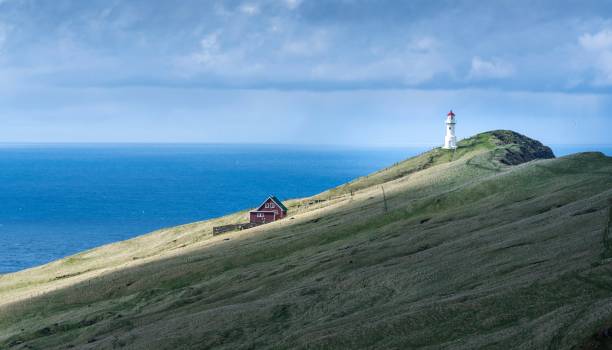 istock Beautiful lighthouse on the rock by the beach 1451154158