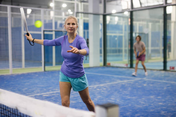 istock Woman serving ball while playing padel in court 1451160082