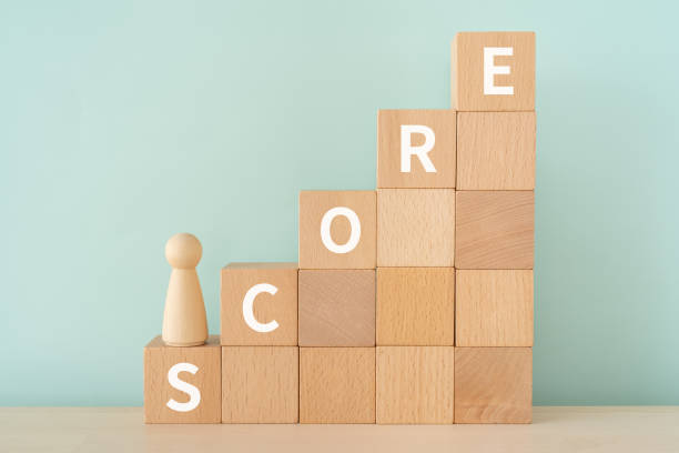 blocchi di legno con testo concettuale "score" e un giocattolo umano. - segnare foto e immagini stock