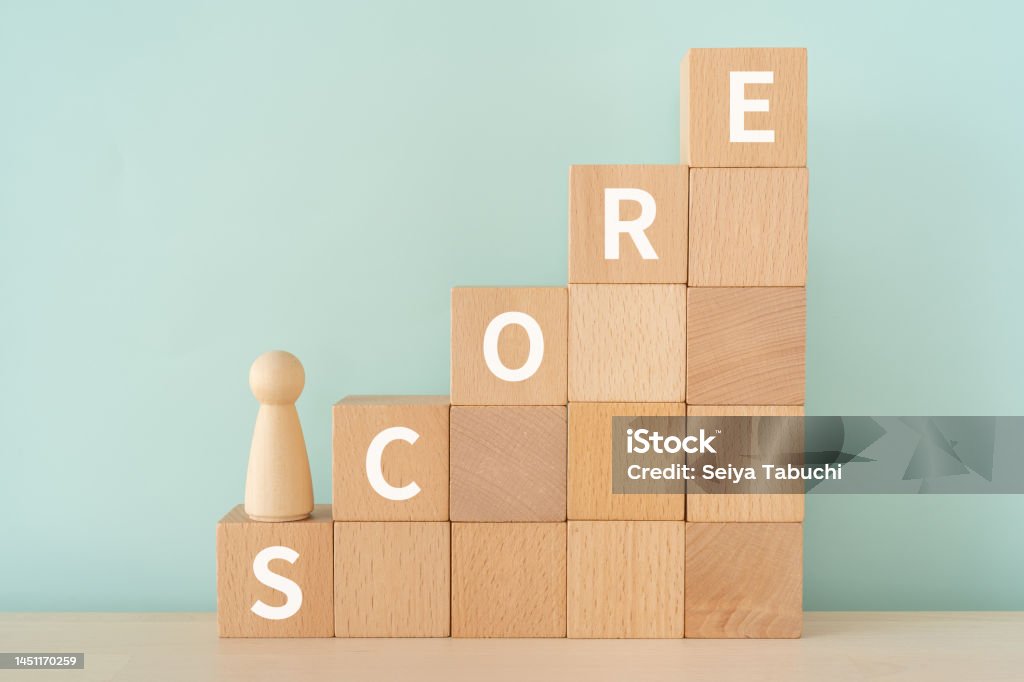 Wooden blocks with "SCORE" text of concept and a human toy. Score Card Stock Photo