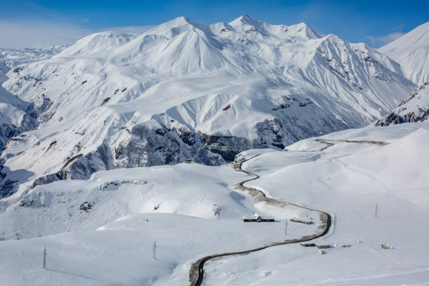 istock Lonely extreme road among white snow in high mountains 1451175826
