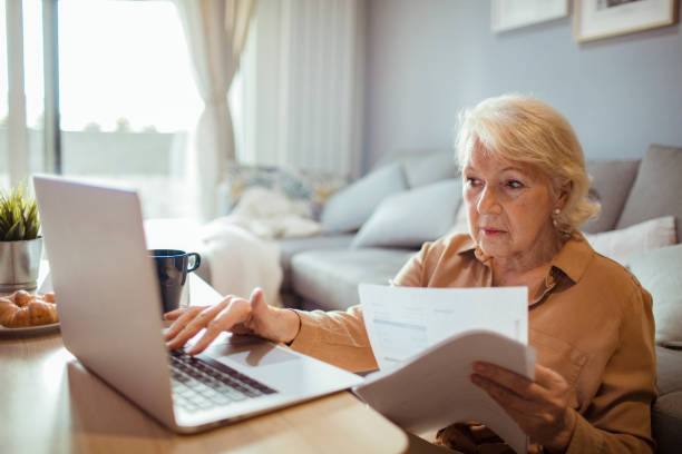 istock Senior woman going over her bills 1451181030