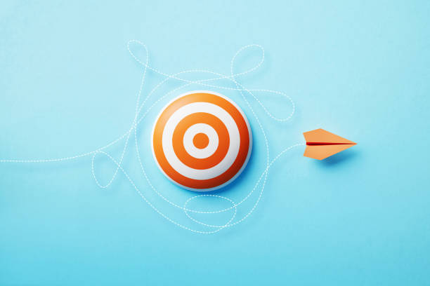 istock Paper Plane Flying  Around An Orange Bull's Eye Target On Blue Background 1451181292