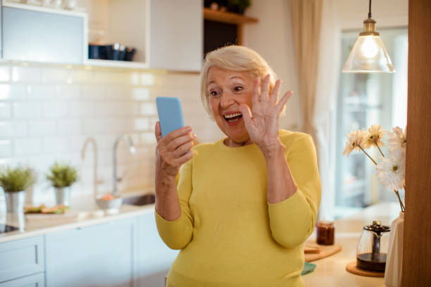 istock Senior woman using her phone at home 1451182601
