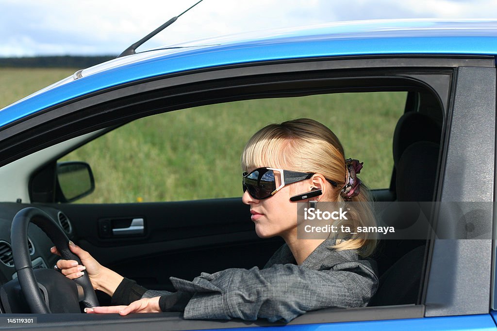 Giovane donna bionda mette un'automobile blu - Foto stock royalty-free di Automobile