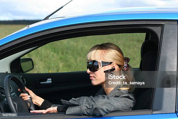 Foto de Loira Jovem Passando Em Um Azul Car e mais fotos de stock de Bluetooth - Bluetooth, Carro, Adulto