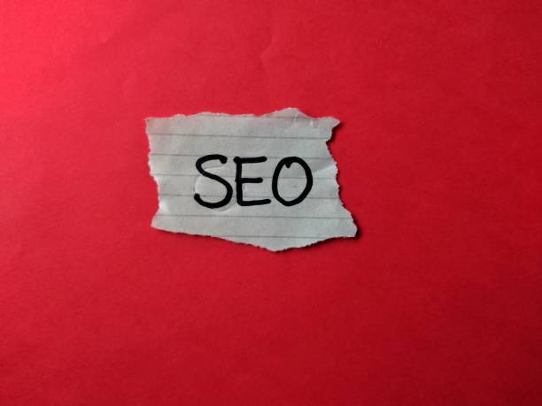 istock Torn piece of paper with phrase SEO on red background, top view 1451194105
