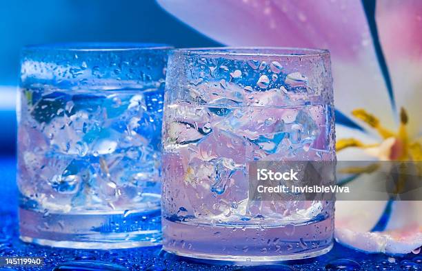 Óculos Com Água E Flor Sobre Azul - Fotografias de stock e mais imagens de Alimentação Saudável - Alimentação Saudável, Azul, Bebida