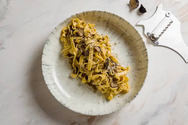 tagliatelli pasta with black truffle on marble table top view