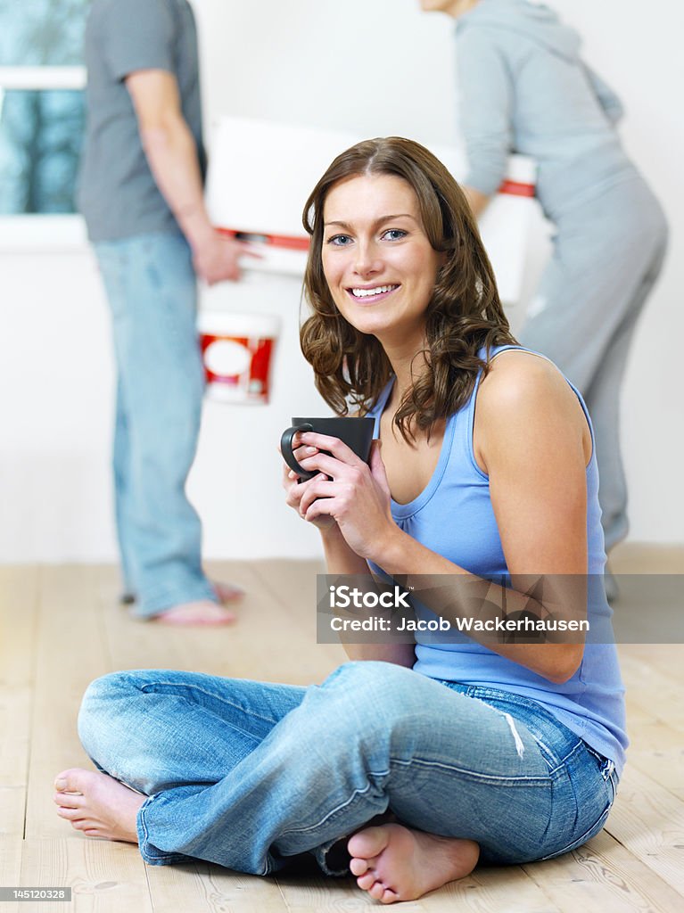 Giovane donna avendo caffè con uomo sollevamento casella in background - Foto stock royalty-free di Abbigliamento casual