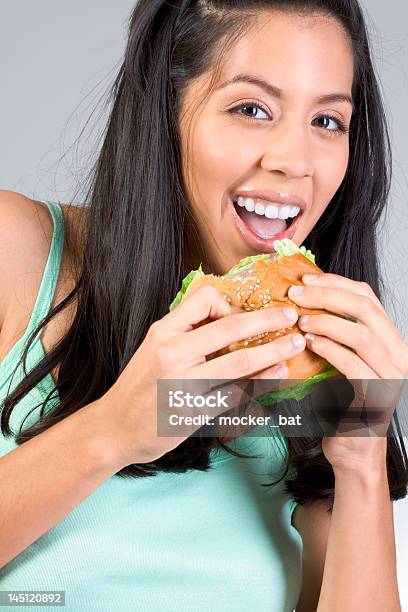 Latina Dziewczynka Jedzenie Burger - zdjęcia stockowe i więcej obrazów 20-24 lata - 20-24 lata, 20-29 lat, Brązowe włosy