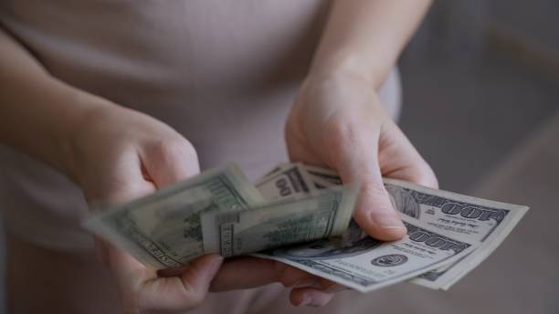 istock Close-up male hands consider paper dollars. 1451213209