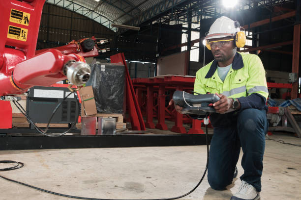 istock Black engineer test and control robotic arm in mechanical manufacturing factory. 1451222354