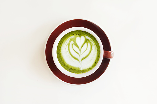 A cup of green tea matcha latte isolated on white background