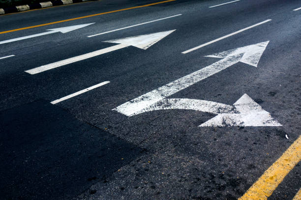 istock White directional arrow signs on asphalt road 1451244911