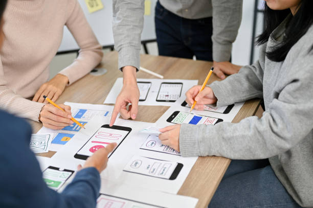 istock Group of millennial Asian mobile application developers startup are in the meeting. cropped image 1451246539