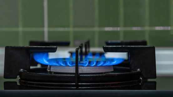 Burning gas stove burner close-up.